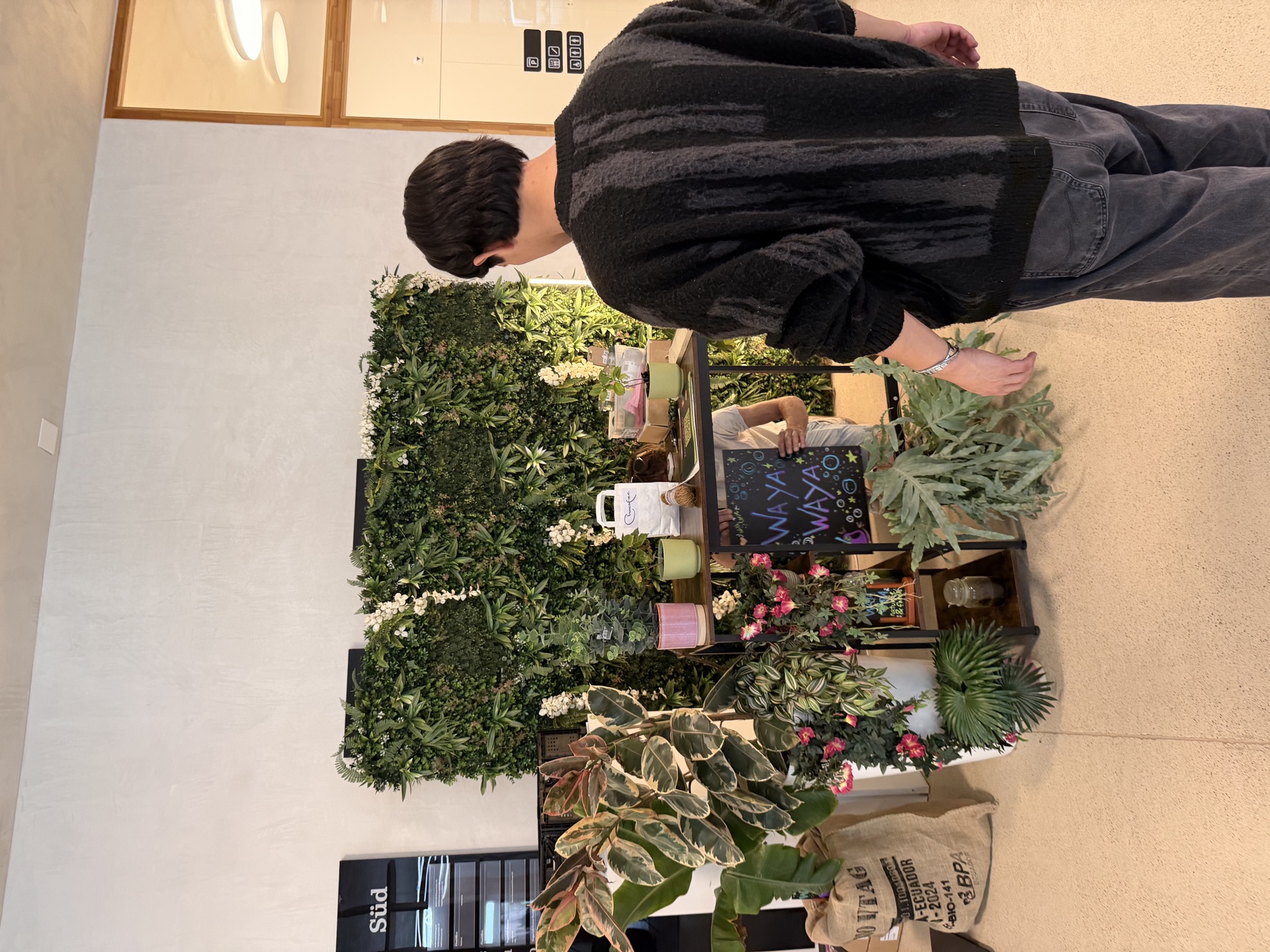 Aufbau des WAYA-Standes mit Pflanzen, Blumen und Tafel-Beschriftung