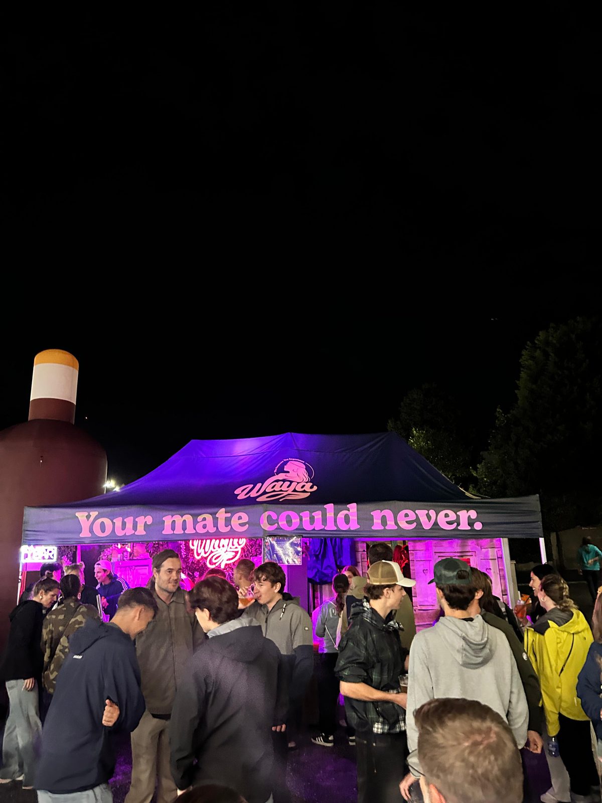 WAYA-Stand am Sound of Glarus bei Nacht mit dem Banner «Your mate could never.»